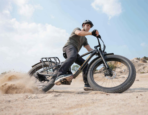 Fat tire ebike conquers sandy dunes adainst a sunset backdrop 